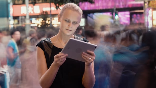 A person using a tablet at a biotech event, navigating an event app. The screen shows profiles of attendees and a schedule of sessions. The background is blurred, with other professionals walking by.