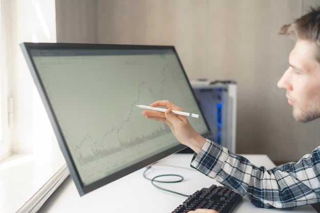 A person analyzing data charts and graphs on a computer screen, with a notepad and pen nearby