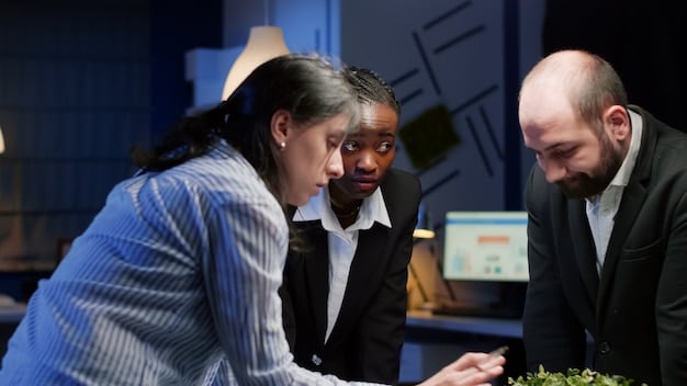 A diverse group of professionals engaged in a dynamic meeting around a table, with projections of data and graphs on a screen nearby, illustrating strategic discussion and investor presentations.